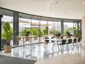 a dining room with a table and chairs and plants at B&B HOTEL Latina in Latina