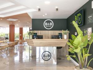 a restaurant with a bar in the middle of a lobby at B&B HOTEL Latina in Latina