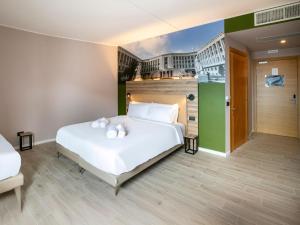 a bedroom with a white bed with towels on it at B&B HOTEL Latina in Latina +16 photos
