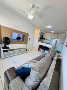 a living room with a couch and a flat screen tv at Lindo APTO na Ponta Verde in Maceió