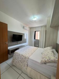 a bedroom with a bed and a flat screen tv at Lindo APTO na Ponta Verde in Maceió +22 photos