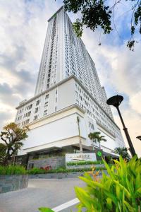 a tall white building with a store in front of it at Stay With Me CBD Apartment - Rivergate Building in Ho Chi Minh City