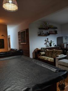 a living room with a table and a couch at Chácara Palma in Ubatuba