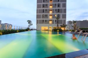 a large swimming pool in front of a building at Stay With Me CBD Apartment - Rivergate Building in Ho Chi Minh City