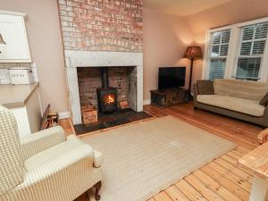 a living room with a fireplace and a couch at Armstrong Cottages No6 in Bamburgh
