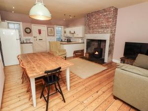 a living room with a table and a fireplace at Armstrong Cottages No6 in Bamburgh
