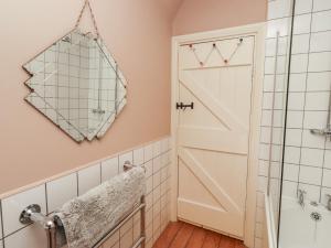 a bathroom with a door and a mirror at Armstrong Cottages No6 in Bamburgh +25 photos