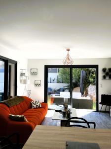 a living room with an orange couch and a bedroom at L'Immortelle in Zonza