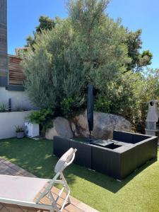 a chair sitting next to a fountain in a garden at L'Immortelle in Zonza
