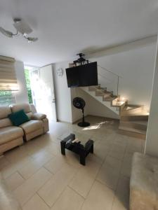 a living room with a couch and a staircase at Casa de Verano Málaga Confort Sol y Piscina in Ricaurte +38 photos