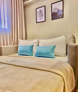 a bedroom with two blue pillows on a bed at Studio Prime, no centro de CWB in Curitiba