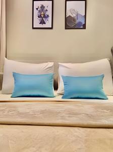 a bedroom with two blue pillows on a bed at Studio Prime, no centro de CWB in Curitiba