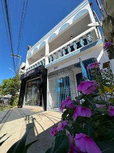 a building with purple flowers in front of it at CASA MARAGOGI 3 Quartos in Maragogi