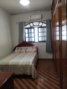 a small bedroom with a bed and a window at Casa Branca in Vila Velha