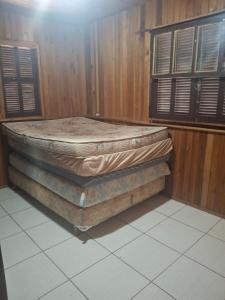 a stack of mattresses sitting in a room with windows at Casa da praia sulmar in Balneário Gaivotas