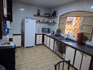 a kitchen with a white refrigerator and a window at Hostel Repou-Z in Goiânia