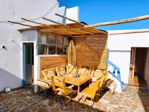 a table and chairs on a patio with a surfboard at SURF TRIP ROOM IN OUASSANe in Essaouira