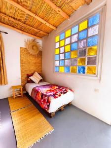 a bedroom with a bed and a stained glass window at SURF TRIP ROOM IN OUASSANe in Essaouira
