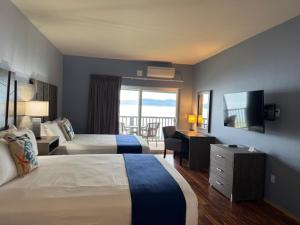 a hotel room with two beds and a flat screen tv at The Waterfront at Potlatch in Shelton