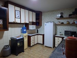 a kitchen with a refrigerator and a stove at Hostel Repou-Z in Goiânia