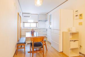a kitchen with a table and chairs in a room at North Nagano Inn in Iiyama