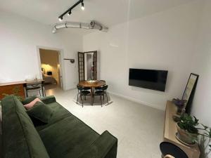 a living room with a green couch and a table at The Hidden Mint - Valletta in Valletta