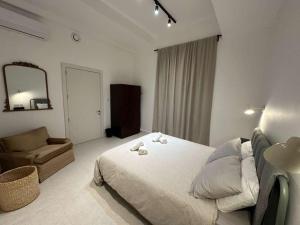 a bedroom with a bed and a couch and a mirror at The Hidden Mint - Valletta in Valletta