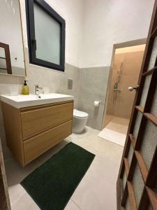 a bathroom with a sink and a toilet and a mirror at The Hidden Mint - Valletta in Valletta +11 photos