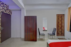 a bedroom with a bed and a table and chairs at Hotel O ALISHA LODGE in Āsansol +18 photos