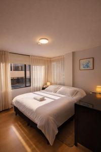 ein Schlafzimmer mit einem großen Bett und einem Fenster in der Unterkunft Hotel Oicatá in Duitama