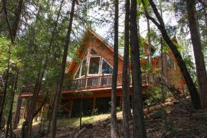 a log cabin in the woods with trees at Rivercrest Lodge with Hot Tub-Pool Table-Firepit in North Wawona