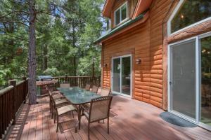 a wooden deck with a table and chairs on it at Rivercrest Lodge with Hot Tub-Pool Table-Firepit in North Wawona