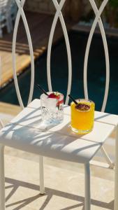 two drinks sitting on a white table next to a pool at Villa Peri Alacati in Alaçatı