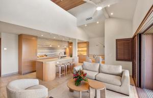 a living room with a couch and a kitchen at Puunoa Beach Estate in Lahaina
