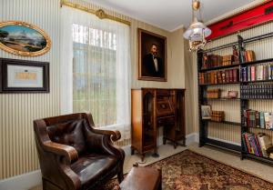 a living room with a chair and a book shelf at US Grant Guest House in Galena +8 photos