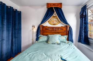 a bedroom with a bed with blue curtains at US Grant Guest House in Galena