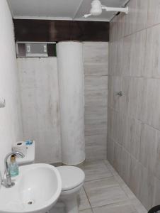a bathroom with a white toilet and a sink at Chalés na Montanha em Poços de Caldas in Poços de Caldas +37 photos