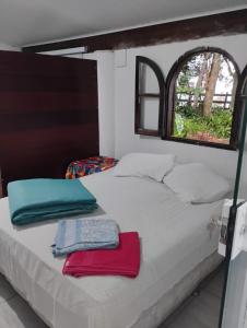 a bed with towels on it in a room at Chalés na Montanha em Poços de Caldas in Poços de Caldas