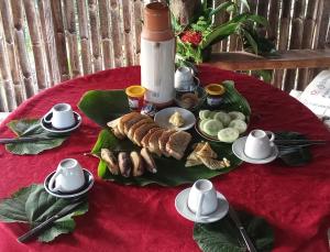 a table with a plate of food on a red table cloth at Tanna Lava View Bungalows in Lénakel +74 photos
