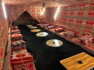a room with tables and chairs in a room with red walls at قمه التجلي in Saint Catherine +38 photos