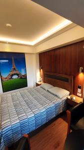 a bedroom with a bed with a picture of the eiffel tower at HOTEL Y MOTEL SAVOY - Santiago in Santiago
