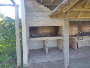 an outdoor kitchen with a fireplace in a brick wall at Cabaña don Cencio in San Pedro
