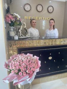 ein Strauß rosa Rosen vor einem Spiegel in der Unterkunft Diamond Hotel in Chişinău + 45 Fotos
