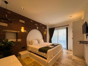 a bedroom with a large bed with a brick wall at Villa Peri Alacati in Alaçatı