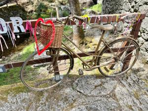 a bike with a heart basket sitting on a bench at Moinho de Brião in Montalegre