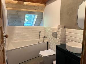 a bathroom with a tub and a toilet and a sink at Całoroczny dom nad Jeziorem Rożnowskim in Gródek Nad Dunajcem