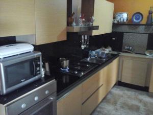 a kitchen with a microwave and a stove top oven at Nely y Pietro share apartment in Punta Cana