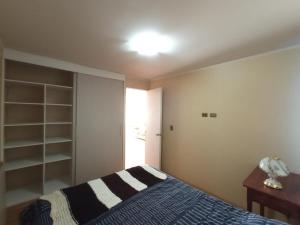 a bedroom with a bed and a lamp and a desk at Casa Labranza estacionamiento 2 dormitorios amoblada Jorge Alessandri 0979 in Temuco