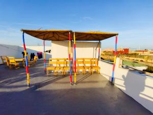 a group of tables and chairs on a roof at Momo Surf Housse in Wassane +21 photos