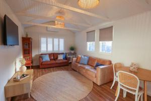a living room with a couch and a table at Bungalow Blue - 8 Illawong Lane in Evans Head